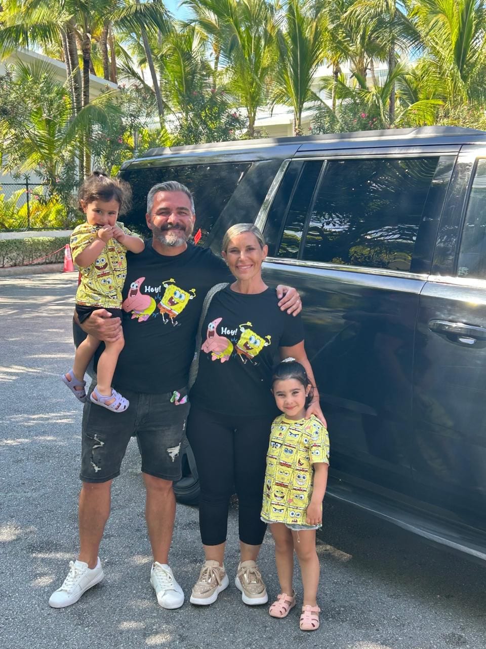 Familia junto a una Suburban negra a la entrada de un resort